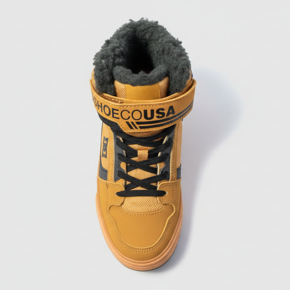 Tan sneaker with black laces on a dark surface