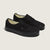 Pair of black sneakers on a light beige background