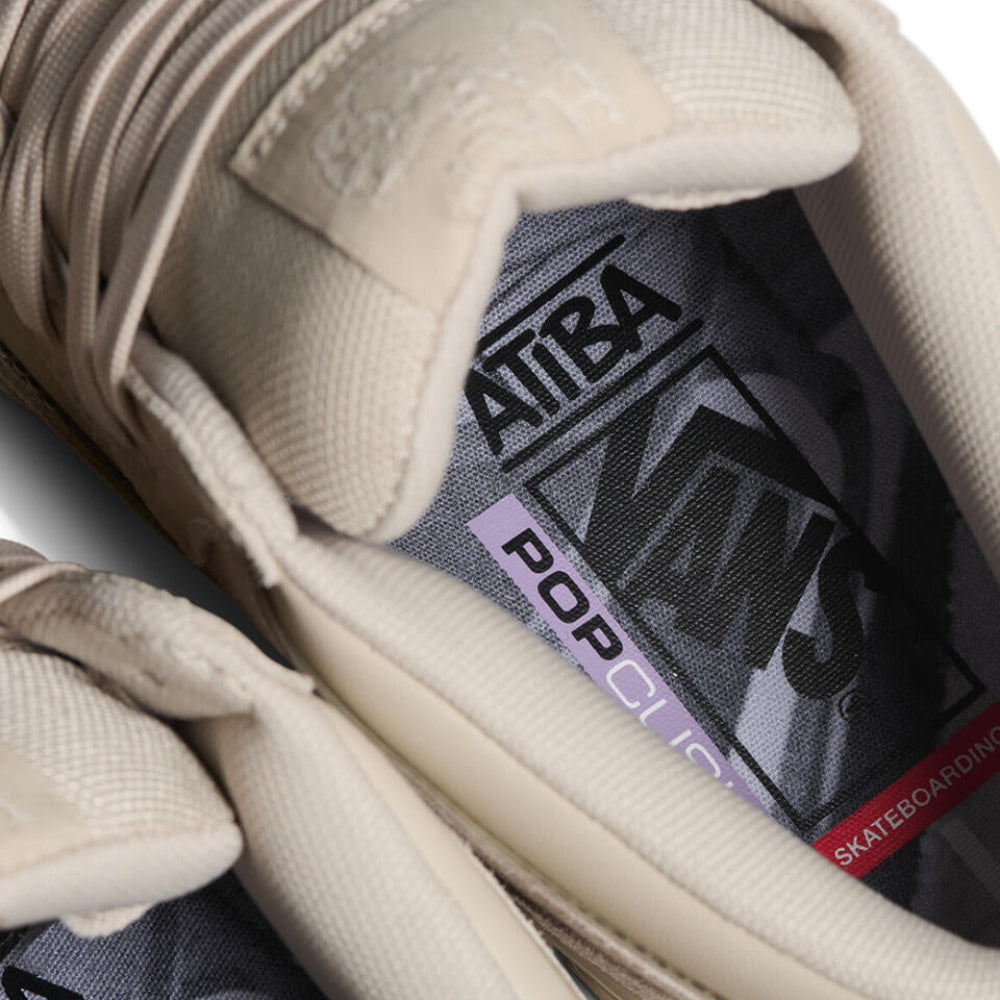 Close-up of a beige sneaker with a visible brand label on the insole.